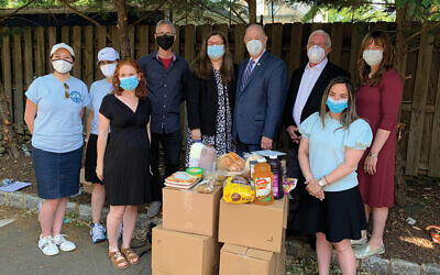 Those at last week’s kosher food pickup include, back row, from left, Rebecca Hindin, Mandi Perlmutter, Steve Karp, Assemblywoman Annette Quijano, Elizabeth Mayor J. Christian Bollwage, Assemblyman Gary Schaer, and Yael Bleicher. In front is staff from Teach NJ, including Katie Katz, at left, and Renee Klyman. Photos by Johanna Ginsberg