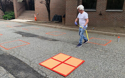 Mike Cumberton painting boxes in the parking lot at Synagogue of the Suburban Torah Center in Livingston. Each box will serve as a member’s personal space when services resume outdoors on June 4. Photo by Johanna Ginsberg