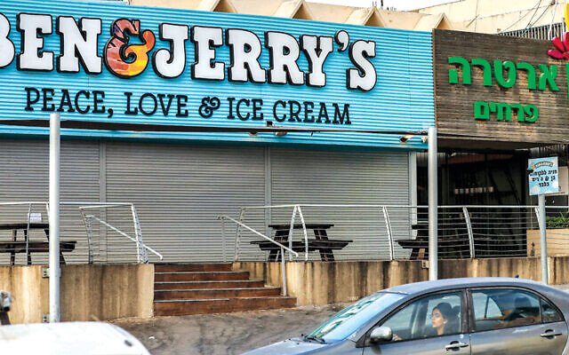 A woman drives past a closed Ben & Jerry’s store in Yavne, south of Tel Aviv, on July 23. (Ahmad Gharabli/AFP via Getty Images)