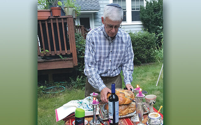 Andy Silver makes motzei in his backyard as his family watches.