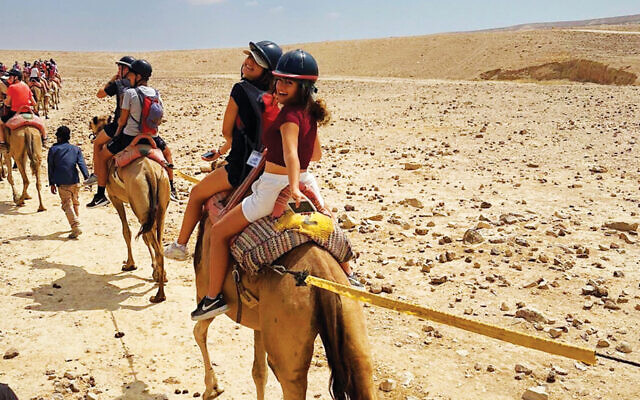 Yaara Nahar, right, looks back from her seat on a camel. Yaara Nahar, right, looks back from her seat on a camel.
