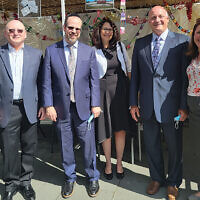 Arielle Greenbaum Saposh, Sinai’s associate managing director, left, with Sam Fishman, managing director; Rabbi Dr. Yisrael Rothwachs, dean; Pam Ennis, director of development; Michael Maron, Holy Name CEO; and Abigail Hepner Gross, Sinai’s director of communications, at the hospital’s annual Sukkot Lunch and Learn in its sukkah. Due to flood remediation, the sukkah was moved to the first floor employee cafeteria patio. Mr. Maron spoke about working together, coming together in crisis, how “me” has overtaken “we,” drawing on Rabbi Jonathan Sacks. The event is attended by Holy Name staff (not only the Jewish staff) and those they invite from other agencies they partner with. (Jeff Rhode)
