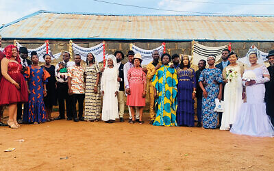 After they were converted, 11 Igbo couples were remarried in Jewish ceremonies. The chuppot they used are behind them.