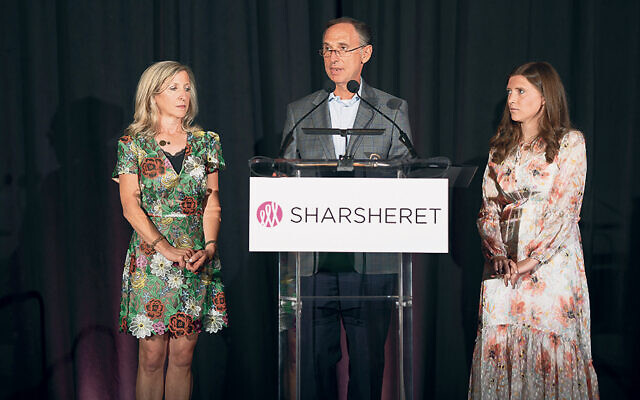 Michael Goldsmith speaks at the Sharsheret barbecue; he stands between his wife, Joy Goldsmith, and one of his three daughters, Amanda Goldsmith Fein. (zmargstudios)