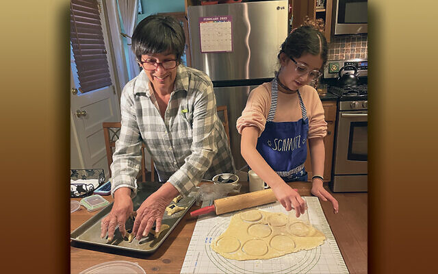 Maayan cuts out the circles after rolling the dough as she makes hamantaschen with her grandmother, Abby Meth Kanter.