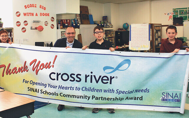 Cross River CEO Gilles Gade stands with students at Sinai at RYNJ in 2019. (Sinai Schools)