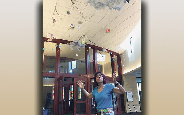 Anne Luria Burg installs the “Soaring into 5783” birds art installation at Congregation Agudath Israel in Caldwell.