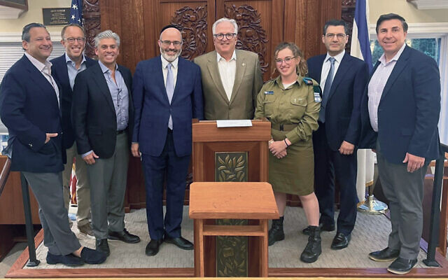 James Schwalbe, left, with Elias Marcovici, East Hill Synagogue president Jonathan Thurm, Rabbi Zev Reichman, FIDF NJ director Howard Gases, Corporal Anna, FIDF CEO Steve Weil, and Howard Shafer. (Courtesy FIDF)