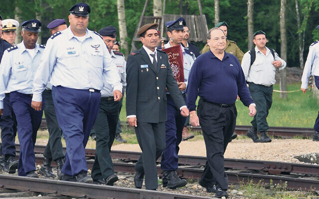 Mr. Foxman walks on railroad tracks to Auschwitz on the March of the Living.
