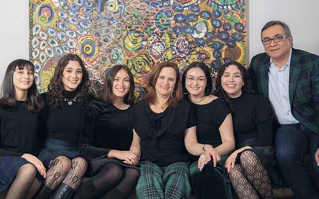 Lori Fein, center, and her husband, Marty Ramirez, sit with their daughters; from left, they’re Israela (Izzi), 13; Dahlia, 19; Margalit, 20; Aviva, 23; and Adiel, 16. (David Zimand)