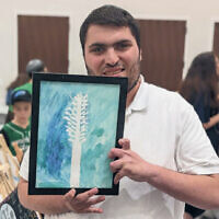 A Sinai student holds his painting.