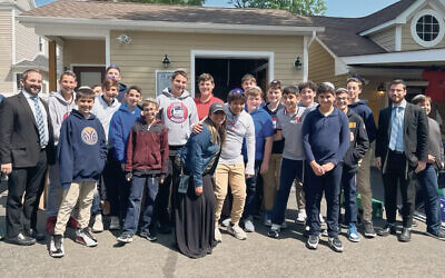 Azi Feuerberg, center, in gray sweatshirt and tan pants, and his mom, Aliza, to his left, are with Azi’s classmates, teachers, and administrators from the JEC. They include Rabbi Ben Pomper, the school’s assistant principal, far left, and teacher Elchanan Preil, right. (Photos courtesy JFS Central NJ)