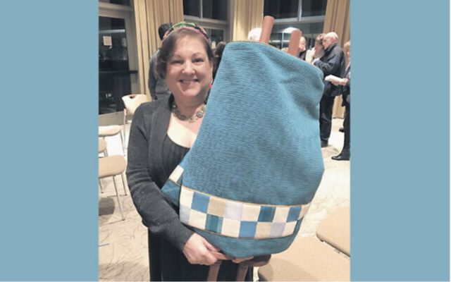 Linda Coppleson holds a sefer Torah she wrote; she’s at a siyyum to celebrate it at Temple Am Shalom in Glencoe, IL.
