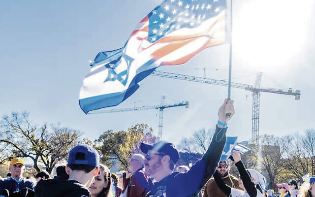 A rallygoer holds a combined American-Israeli flag; those flags were everywhere at the rally. (Mendy Moscowitz)
