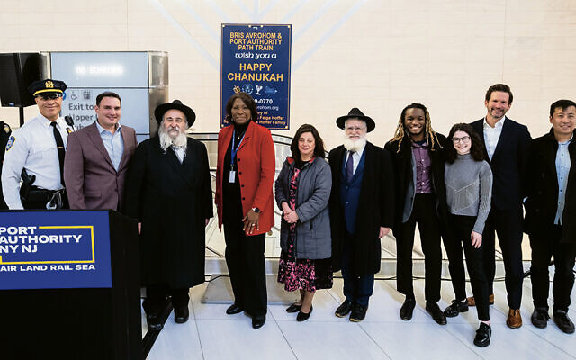 Rabbi Mordechai Kanelsky, third from left, Clarelle DeGraffe, and the Hoffers, next to her, stand among Port Authority workers at the WTC.