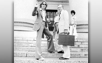 Leon Wildes looks bemused as John Lennon flashes a peace sign on the steps of the federal courthouse in Manhattan.