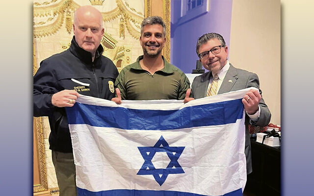 From left, Morris County Sheriff James Gannon, Noam Buskila, and state Senator Anthony Bucco hold an Israeli flag.