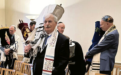 Scribe Neil Yerman carries a Holocaust Torah scroll from Temple Sholom in Scotch Plains at a ceremony in London. (Courtesy Temple Sholom)