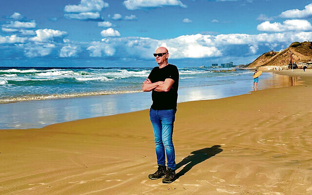 In a still from “The Road Between Us,” Noam Tibon stands on the beach.