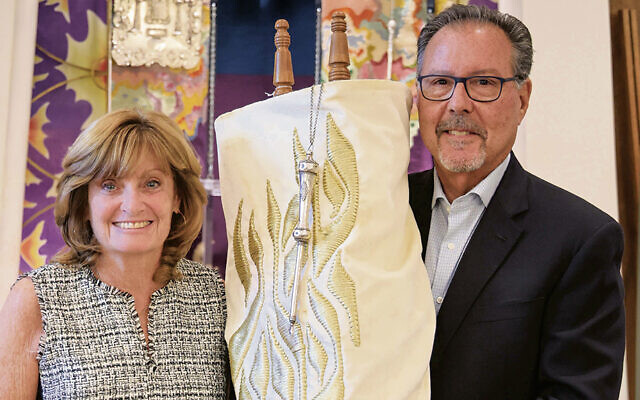 ON THE COVER: In Fair Lawn, Arlene and Stuart Liebman hold the Torah they have dedicated and are donating in memory of Arlene’s parents, Holocaust survivors Sol and Miriam Moskowitz.