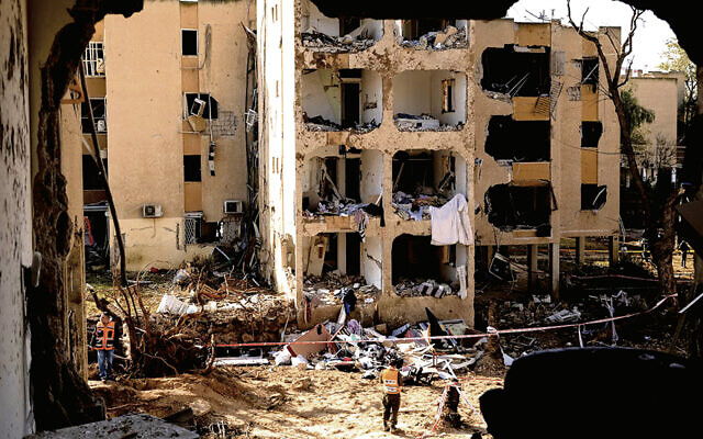 An emergency responder stands near destroyed buildings after an Iranian missile strike on March 22 in Arad, Israel. (Amir Levy/Getty Images) An emergency responder stands near destroyed buildings after an Iranian missile strike on March 22 in Arad, Israel. (Amir Levy/Getty Images)