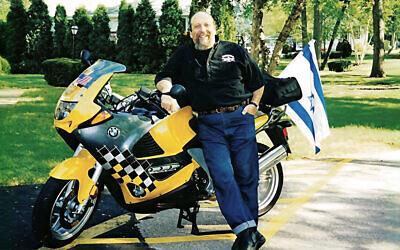 Lenny Mandel stands in front of the motorcycle, complete with Iraeli flag, that his friend Bobby rode up to West Point.