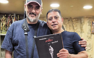 Sharon Gabay, left, stands with the owner of a cafe in Jerusalem’s Muslim Quarter, who’s holding “Jerusalemites.”
