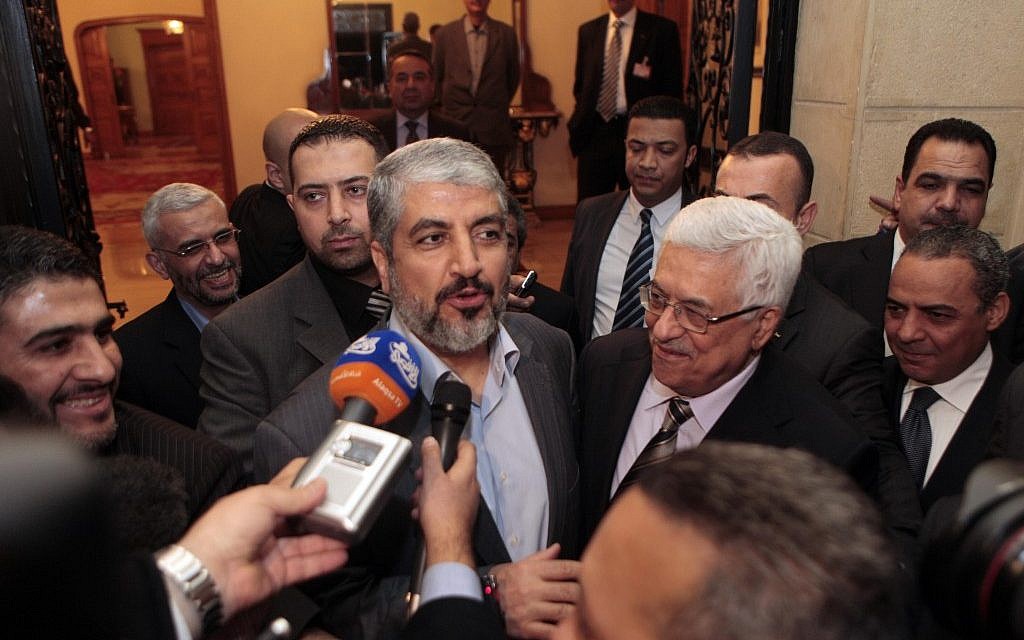 Mahmoud Abbas (center right) and Hamas leader Khaled Mashaal speak to reporters after talks in Cairo in February 2012 (photo credit: Amr Nabil/AP)
