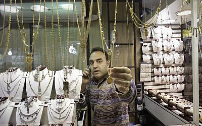 Seorang tukang emas Iran menyesuaikan kalung emas di pasar emas di bazar utama lama Teheran.  (kredit foto: c/o AP)