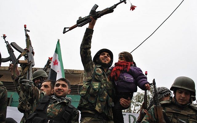 Para pembelot tentara Suriah merayakan tak lama setelah bergabung dengan pengunjuk rasa anti-rezim Suriah di daerah Khaldiyeh di provinsi Homs, Suriah tengah, pada bulan Januari.  (kredit foto: AP / File foto)
