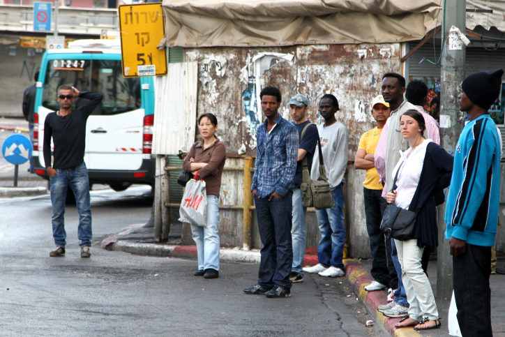 A spectrum of Israeli society including Israelis, refugees, and migrant workers, stand at a bus stop in South Tel Aviv. May 12 2011. (Photo by Nicky Kelvin/Flash90)