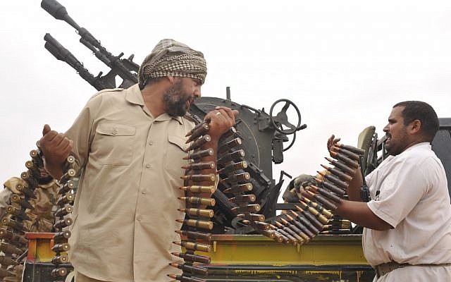 Des combattants révolutionnaires libyens chargent leur mitrailleuse lors d'une attaque contre les forces pro-Kadhafi en 2011. (crédit photo : AP/Bela Szandelszky)