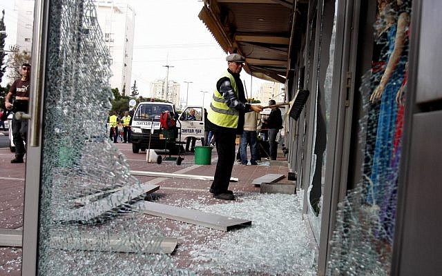 Cleaning up after a Grad rocket fired from Gaza hits the center of Ashdod last Monday. (photo credit: Flash90)*