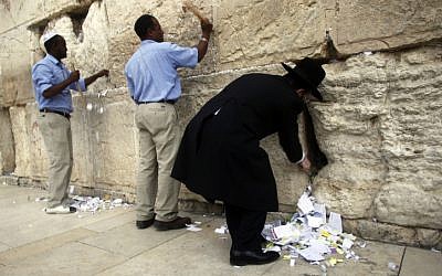Western Wall's Rabbi, Shmuel Rabinowitz, and his helpers remove thousands of handwritten notes placed between the ancient stones of the Western Wall, Judaism's holiest site in the Old City of Jerusalem. (photo credit: Uri Lenz/Flash90)