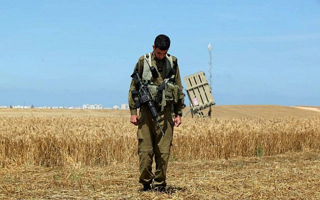 A soldier, standing near an Iron Dome battery in Ashkelon, observes a two-minute silence commemorating fallen soldiers and victims of terror during Memorial Day in 2011 (photo credit: Edi Israel/Flash90)