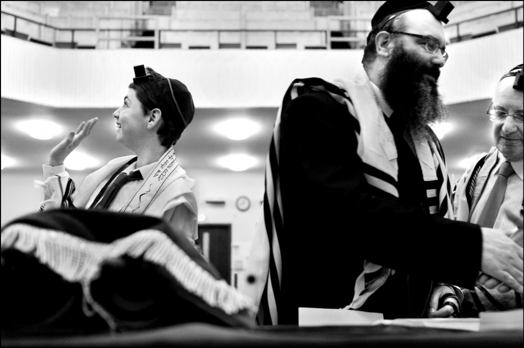 Glasgow 2010. Seorang anak laki-laki bar mitzvah di sinagoga Ortodoks melambai ke arah ibunya yang duduk di balkon.  (kredit foto: Yehuda Passow)