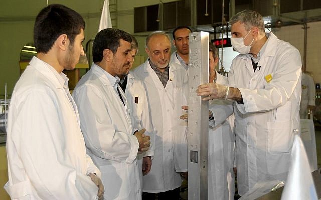 Iranian President Mahmoud Ahmadinejad (second from left) being escorted by technicians during a tour of Tehran's research reactor center in February. (photo credit: AP/Iranian President's Office)