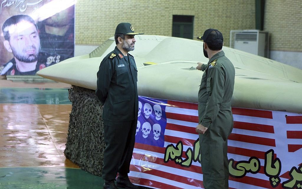 Chief of the aerospace division of Iran's Revolutionary Guards, Amir Ali Hajizadeh (left), near the captured US RQ-170 Sentinel drone in April 2012. (photo credit: AP/Sepahnews)