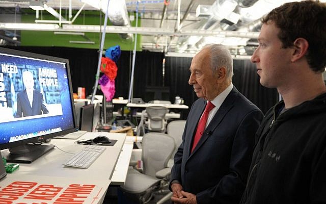 Former President Shimon Peres works on his Facebook page with Mark Zuckerberg, founder of Facebook, looking on (photo credit: Moshe Milner/GPO/Flash90)