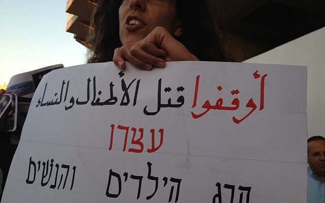 Sebuah tanda dalam bahasa Arab dan Ibrani bertuliskan 'hentikan pembunuhan anak-anak dan wanita' (kredit foto: Elhanan Miller/Times Israel)
