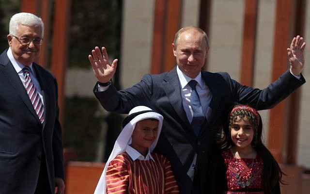 Putin poses with Palestinian children dressed in traditional garb in Bethlehem Tuesday (photo credit: Issam Rimawi/Flash90)