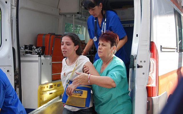 An Israeli tourist is helped as she arrives to Burgas hospital after a bus carrying Israeli tourists in the Bulgarian resort city of Burgas was blown up Wednesday, July 18, 2012 (photo credit: AP/Bulphoto Agency)