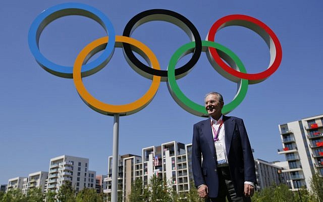 IOC President Jacques Rogge poses in front of the Olympic rings during his visit to the Athletes' Village at the Olympic Park in London, Monday, July 23, 2012. (photo credit: Jae C. Hong/AP)
