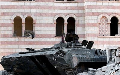 A damaged Syrian military tank is seen at the border town of Azaz, some 20 miles (32 kilometers) north of Aleppo, on Tuesday. (photo credit: AP Photo/Turkpix)