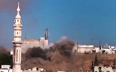 Black smoke rises into the air from shelling near a mosque in Talbiseh, the central province of Homs, Syria, in amateur video released on Monday, July 2. (photo credit: Ugarit News via AP video)