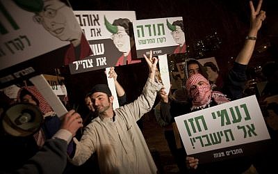 Right-wing activists dressed as Arabs demonstrate against the New Israel Fund in January 2010. The signs show the NIF's president Naomi Chazan with a horn sprouting from her head and accuse the fund of financing organizations that contributed to the Goldstone report (photo credit: AP/Dan Balilty)