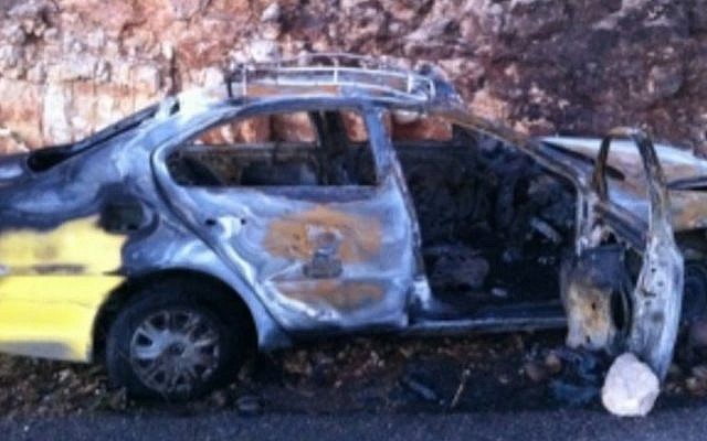 A burnt-out Palestinian taxi in the wake of a firebombing attack near the settlement of Bat Ayin (photo credit: Israel Police)