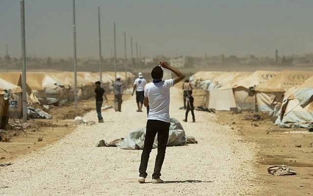 A Syrian refugee drinks water at the Zaatari refugee camp in Jordan, August 13, 2012 (photo credit: AP/Clemens Bilan)
