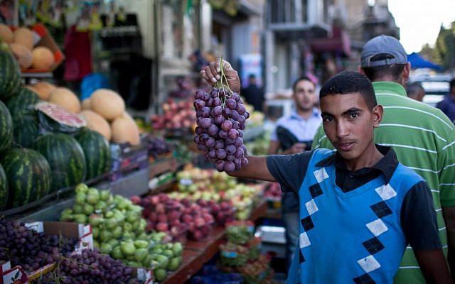 Illustrative: A Palestinian youth in Jerusalem displays his produce during Ramadan, July 24, 2012. (Noam Moskowitz/Flash90)