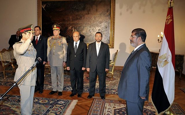 Then-Egyptian president Mohammed Morsi, right, swears in newly-appointed Minister of Defense, Lt. Gen. Abdel-Fattah el-Sissi, left, in Cairo in August 2012 (photo credit: AP/Egyptian Presidency)